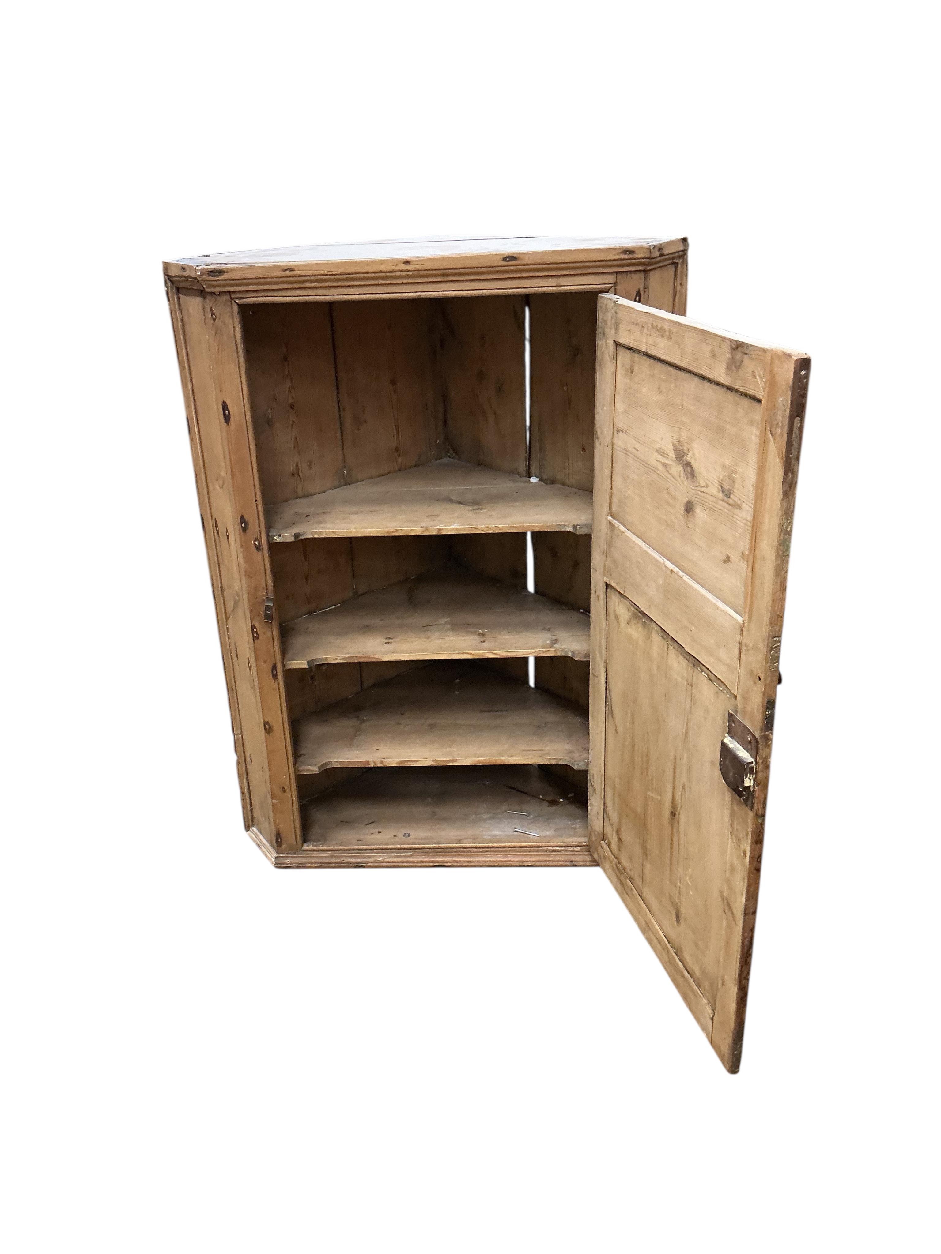 An early 19th century pine hanging corner cupboard, width 67cm, depth 43cm, height 88cm